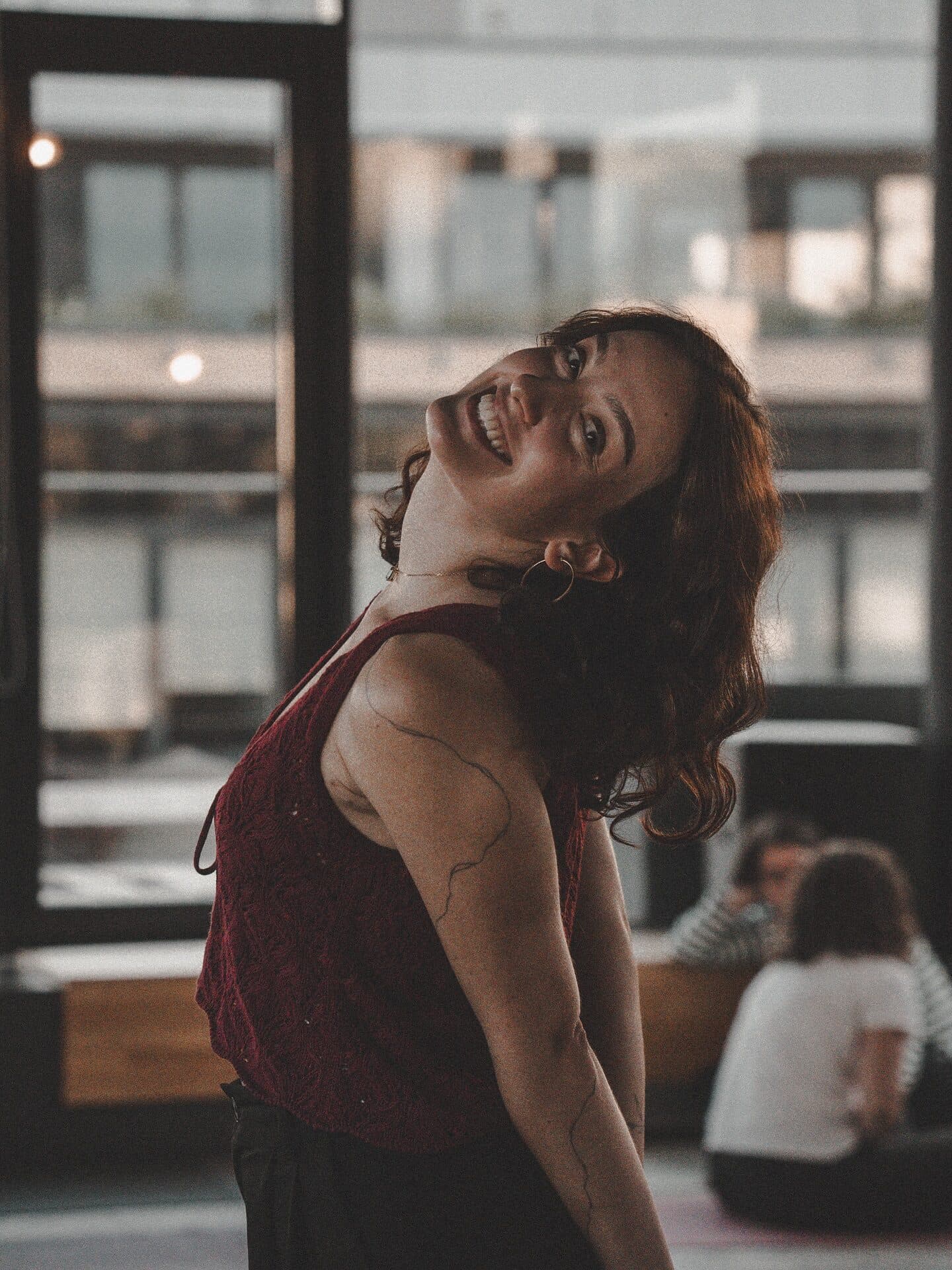 A woman laughing with her head tilted back after a breathwork session