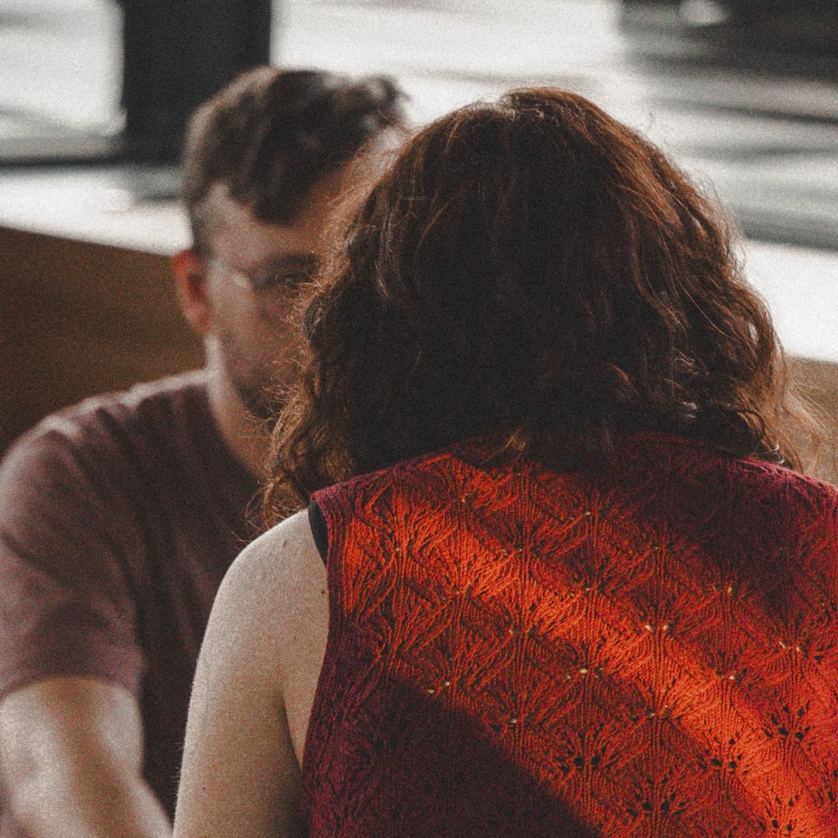 Viktorie, seen from behind in a red knit top, sitting face to face with a participant